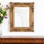Homeroots - 23" Antiqued Gold Ornate Scroll Framed Accent Mirror