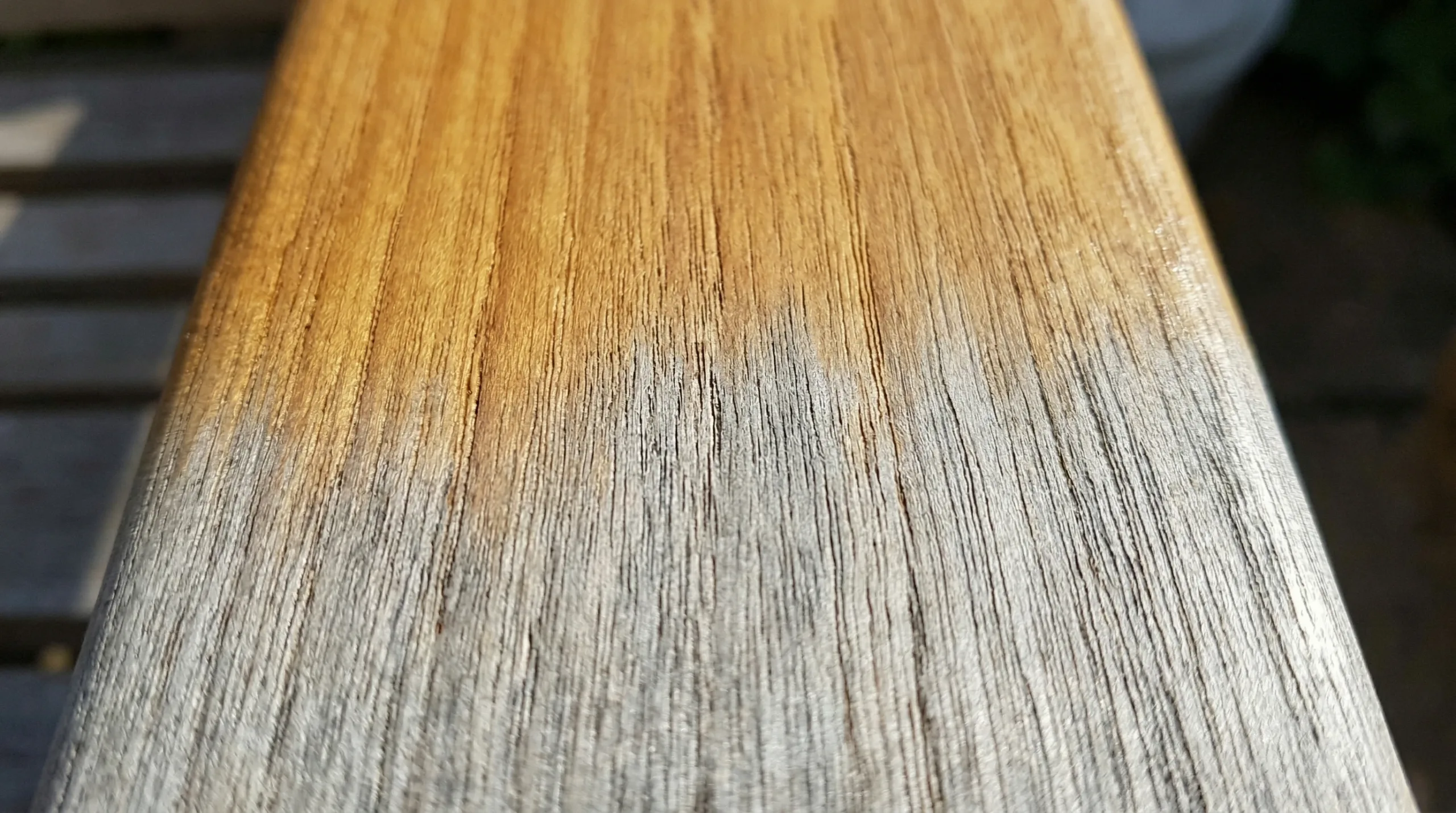 Teak wood grain detail showing natural color transition from gold to silver patina